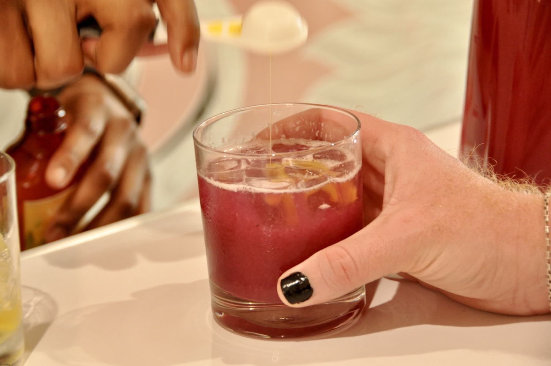 A house-made concentrate poured over ice into a deep magenta cocktail