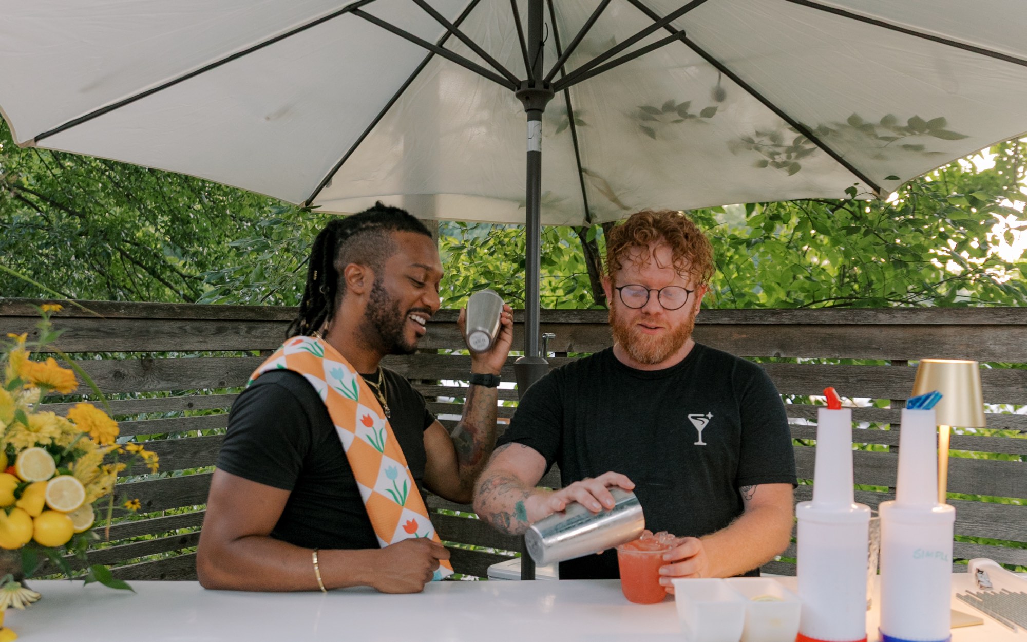 Two bartenders mixing drinks at a styled mobile bar