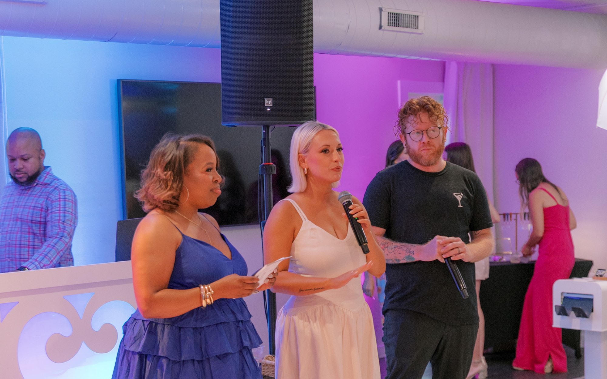 Hosts giving a toast at a party, the bartender at their side